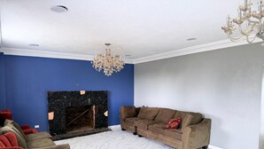Una sala de estar con chimenea, un sofá y un sillón rojo.