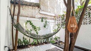 A hammock, a hanging lantern, and a tiled patio area with plants. - Private Oasis, Jacuzzi, Hammock, Water Feature (Ciudad de México)