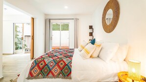 A bedroom with a bed, a mirror, a bedside lamp, and a view of the outdoors. - Private Oasis, Jacuzzi, Hammock, Water Feature (Ciudad de México)