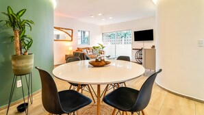 A modern dining area with a round table, black chairs, and a potted plant. - Private Oasis, Jacuzzi, Hammock, Water Feature (Ciudad de México)