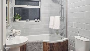 A bathroom with a bathtub, toilet, and sink.