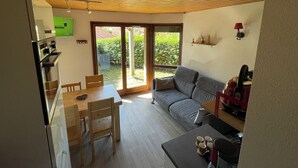 Eine moderne Küche mit Essbereich, einer Couch und einer Schiebeglastür zum Garten.