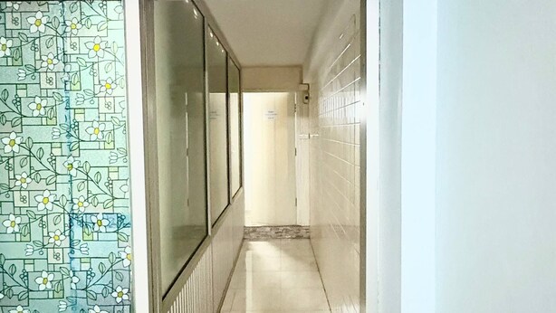 A hallway with a tiled floor, a patterned glass door, and a white ceiling. - Prompt Inn Chareonkrung (Bangkok)