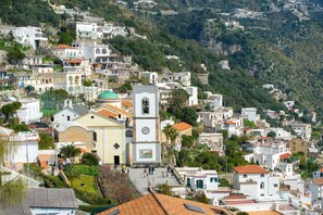 A hillside town with a prominent church, narrow streets, and residential buildings. - The Seagull - Tradewinds (Praiano)
