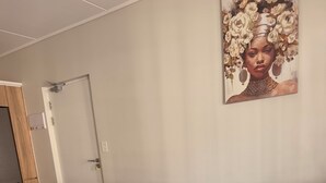 Moderni olohuone, jossa on sininen sohva, valkoinen sohvapöytä ja taulu seinällä.