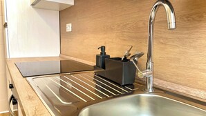A modern kitchen with a stainless steel sink, wooden countertop, and a built-in stove. - Rome Vatican/ Dimora 63 AIR CONDITIONING & WI-FI Premium Apartment (Roma)