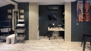 A modern room with a desk, chair, and shelving unit.
