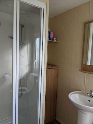 A bathroom with a shower, toilet, and sink. - Seaview Caravan Park - Holiday Accommodation 15514 (Skegness)