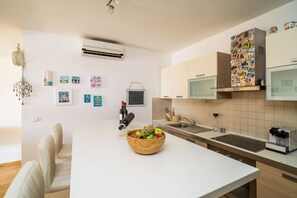 Una cocina moderna con una isla central, microondas y cafetera.