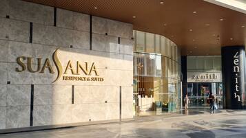 A modern building with a large sign for 'SUASANA RESIDENCE & SUITES' and a glass entrance.