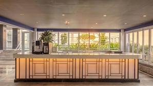 A modern bar area with a large window, a plant, and a counter with glasses. - Suasana JB Central by TPL (Johor Bahru)