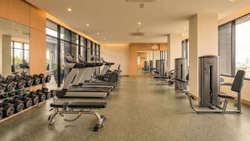 A gym with treadmills, dumbbells, and weight machines.
