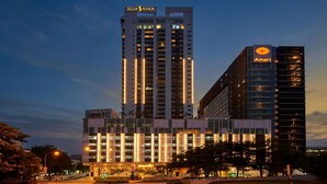 A modern hotel with a prominent 'SUSANA' sign, a 'Marriott' logo, and a 'SASANA' sign on a tall building. - Suasana JB Central by TPL (Johor Bahru)