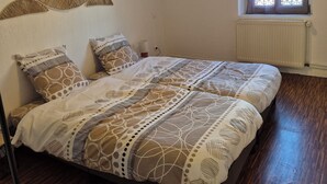 Una camera da letto con un letto, una finestra, un termosifone e una decorazione a parete.