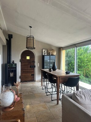 A cozy living space with a wooden dining table, black chairs, a globe, and a suitcase. - Rent house with garden two minutes walk from the village (Cabris)
