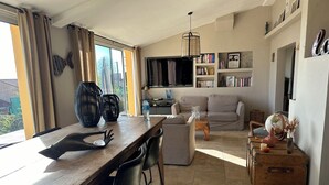 Ein Wohnzimmer mit einer Couch, einem Couchtisch und einem Essbereich mit Tisch und Stühlen.