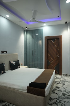 Une chambre à coucher avec un lit, une armoire, une porte et un ventilateur de plafond.