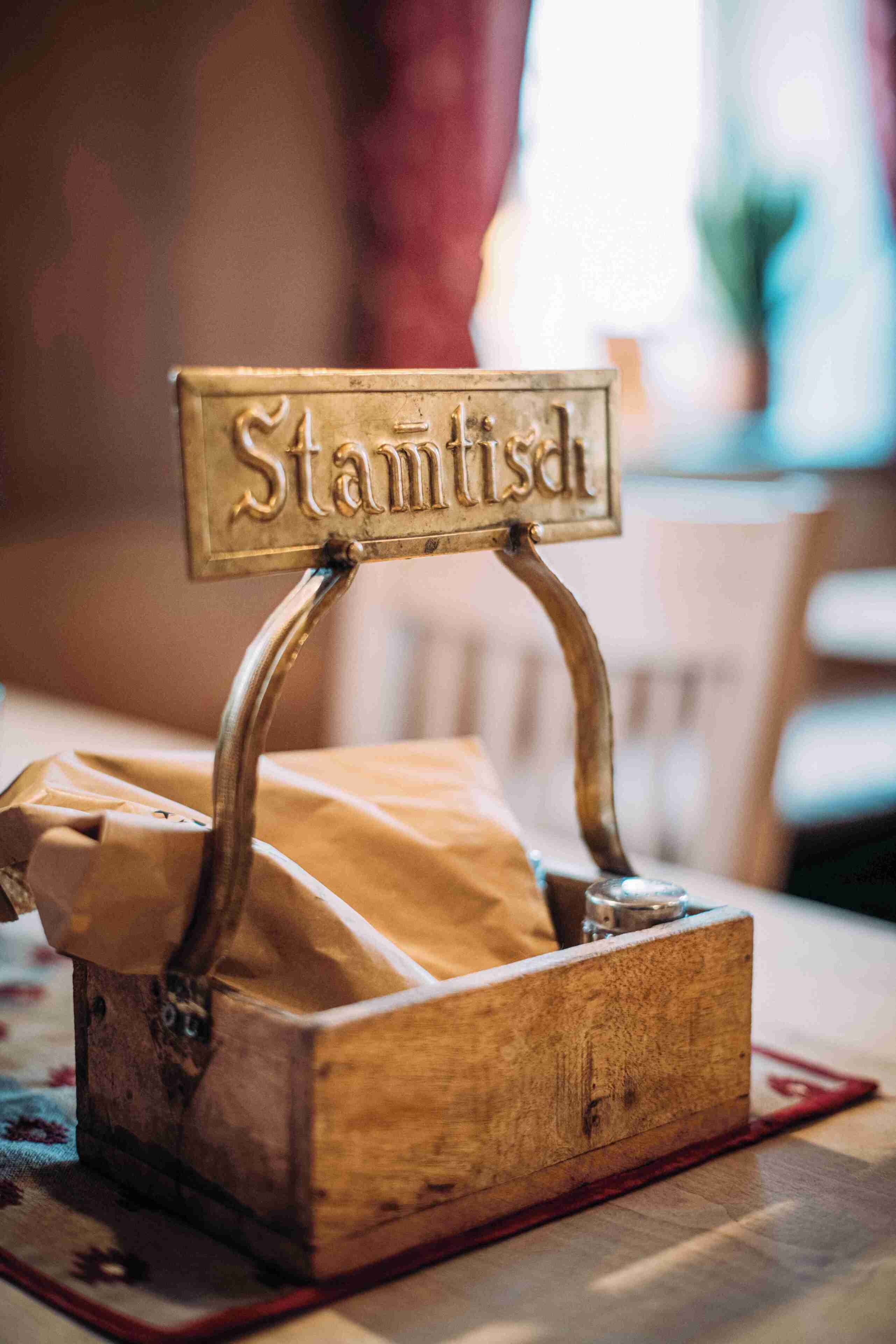 Una caja de madera con un letrero que dice 'Stammtisch' y un portalápices.