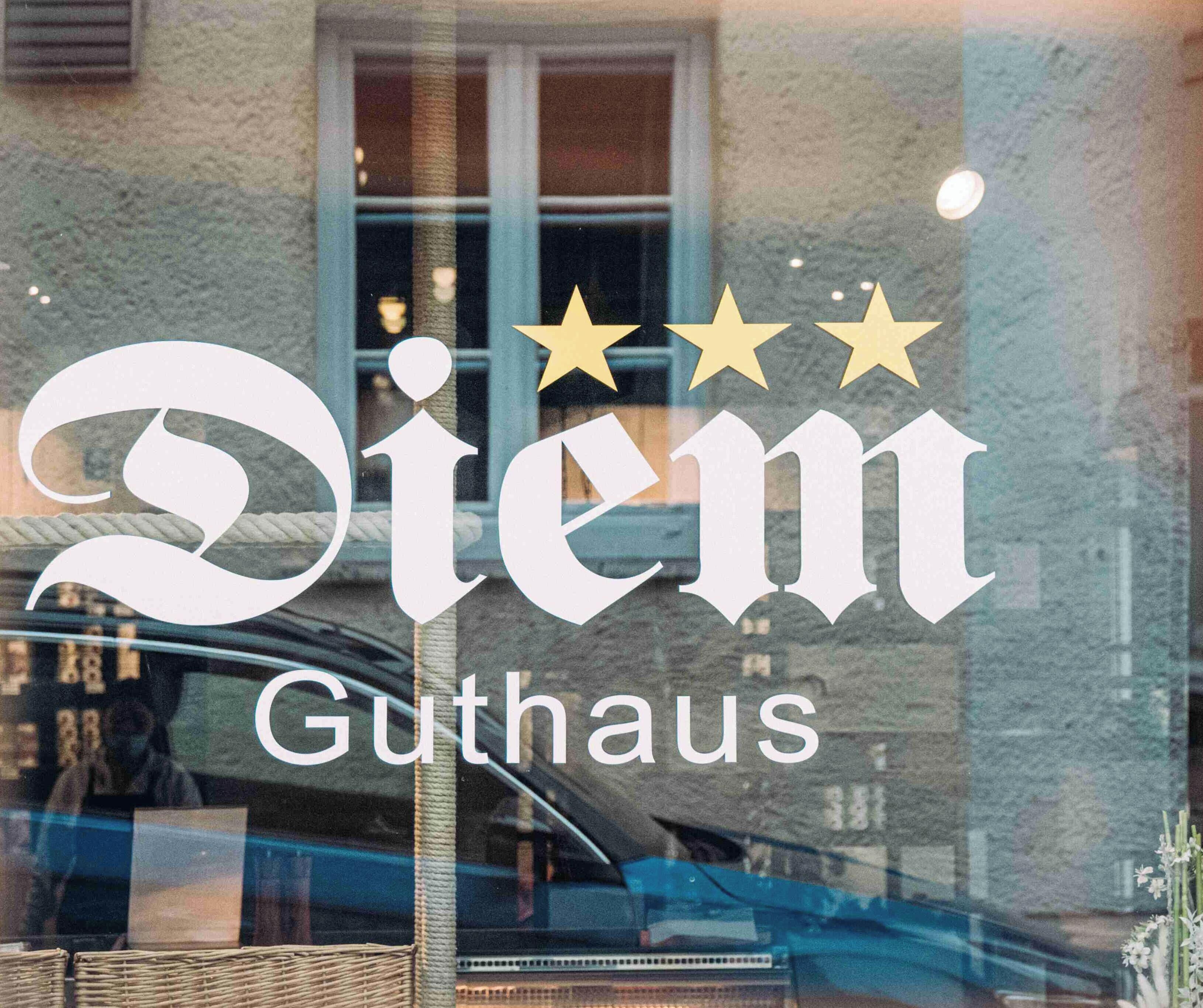 Une fenêtre sur laquelle on peut lire le texte « Diem Guthhaus » et au-dessus, trois étoiles.