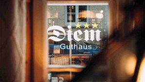 Ett fönster med texten ”Diem Guthaus” och tre stjärnor.