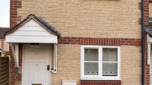 A two-story house with a white front door, a small porch, and a mailbox. - Newly Renovated 2-Bed House w/ Parking – Sleeps 5 Near Shaftesbury Town (Shaftesbury)