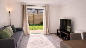 A living room with a sofa, TV, and dining area. - Newly Renovated 2-Bed House w/ Parking – Sleeps 5 Near Shaftesbury Town (Shaftesbury)