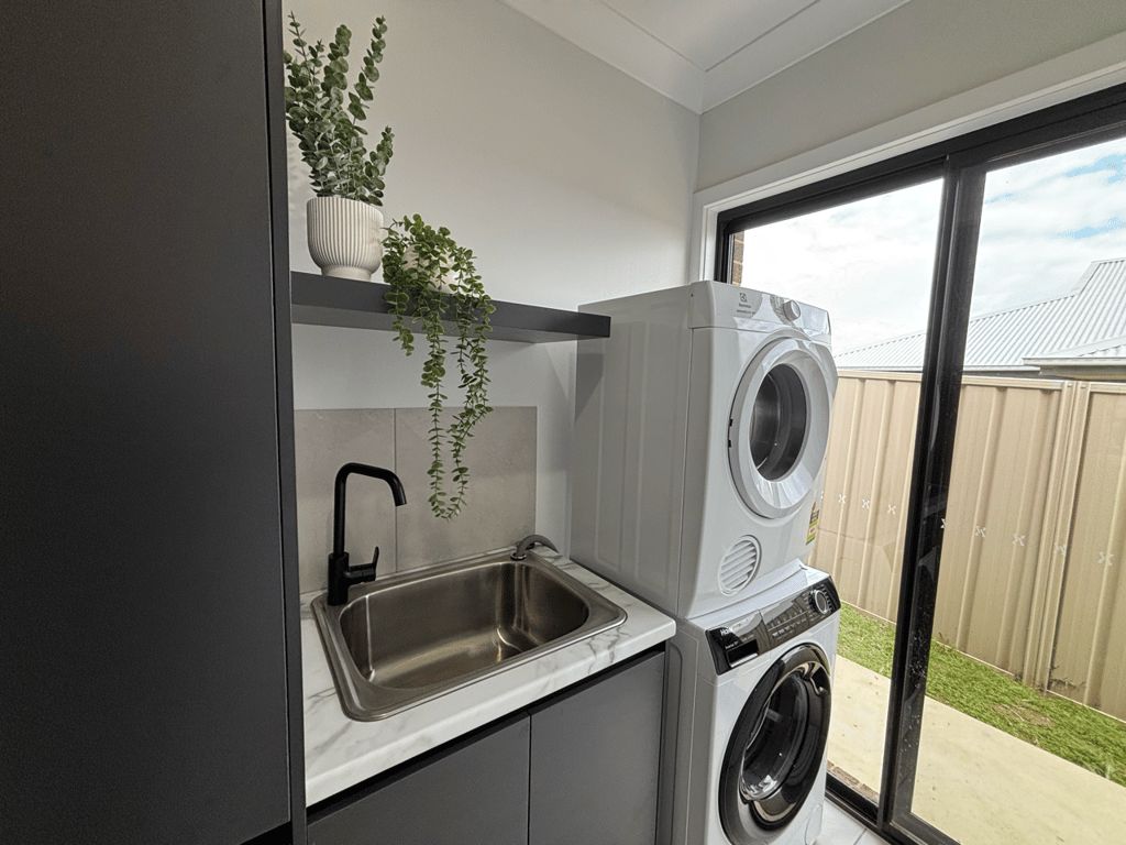 A compact laundry area with a built-in washing machine and a sink.