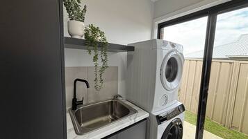 A compact laundry area with a built-in washing machine and a sink.