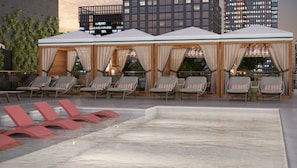 Un área de piscina en la azotea con sillones de descanso y una zona de estar cubierta.