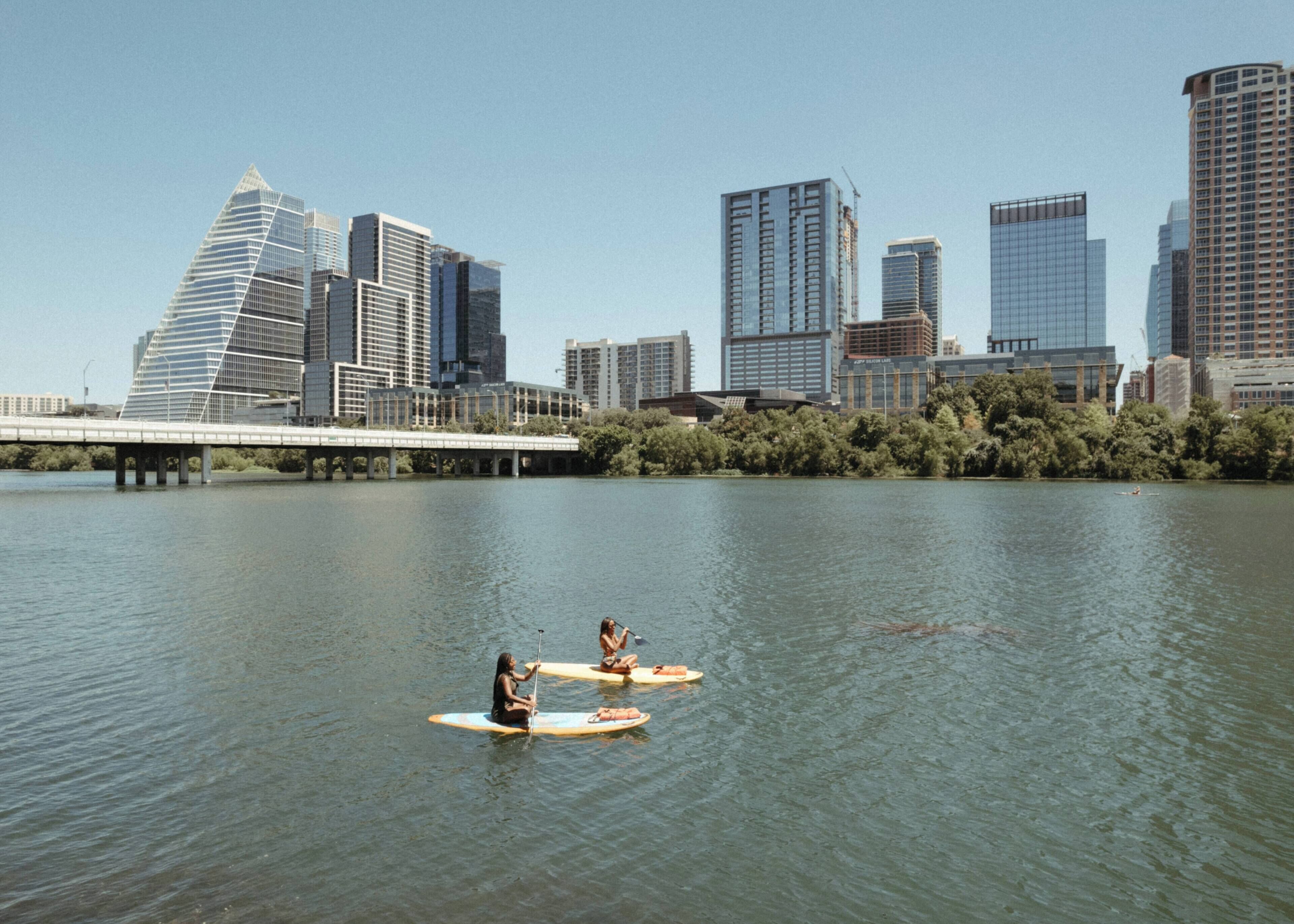 Un paisaje urbano con edificios modernos y un puente sobre el agua.