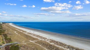 Ein Küstenstrand mit klarem Himmel und einer weiten Sandküste.