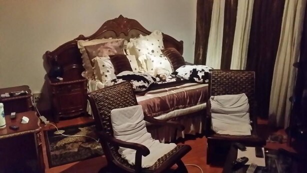 A bedroom with a wooden bed, two upholstered chairs, a nightstand, and a small table with a lamp. - Room-charming B&B Room With Private Entr (East London)