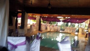 A blurred view of a pool area with chairs and tables, suggesting a resort or hotel setting. - Room-charming B&B Room With Private Entr (East London)