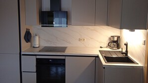 A modern kitchen with a built-in dishwasher, a stove, and a coffee maker.