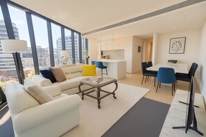 Un salon moderne comprenant un canapé, une table basse et un coin repas avec des chaises et une table.