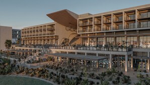 Um hotel com vários andares, áreas de estar ao ar livre e um jardim no deserto.