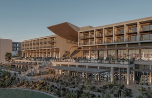 A multi-story hotel with outdoor seating areas and a desert garden.