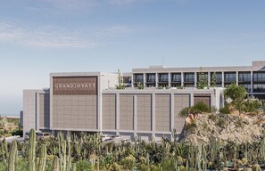 A modern hotel with a prominent 'GRAND HYATT' sign, surrounded by desert vegetation. - Grand Hyatt Los Cabos Resort, Golf & Spa, All-Inclusive (Cabo San Lucas)