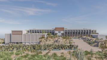 Un hotel con jardín desértico, una estructura en forma de estrella destacada y cielo despejado.