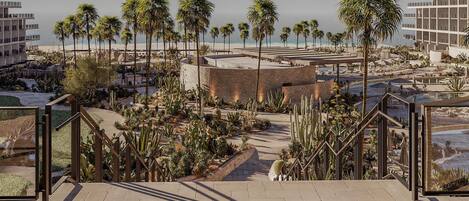 A resort with palm trees, a pool, and a beach view.