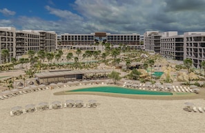 Een resort met meerdere gebouwen, een zwembad en een zandstrand met ligbedden en parasols.