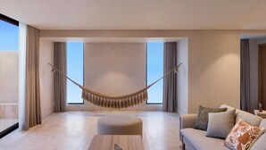 A modern living room with a hammock, a sofa with decorative pillows, and a wooden coffee table. - Grand Hyatt Los Cabos Resort, Golf & Spa, All-Inclusive (Cabo San Lucas)