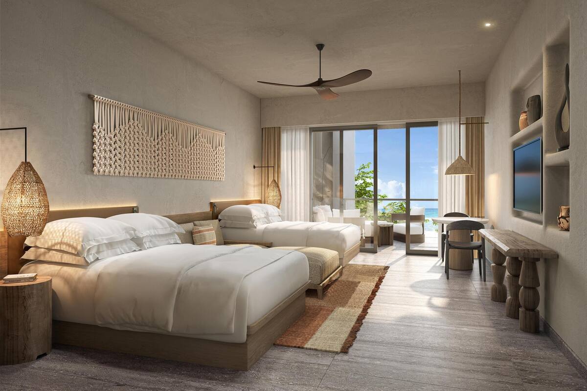 Une chambre d’hôtel moderne dotée de deux lits, d’un ventilateur de plafond, d’une grande fenêtre offrant une vue agréable et d’un téléviseur à écran plat.