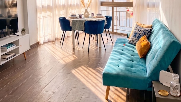 Een moderne woonkamer met een bank, een eettafel en een televisie.