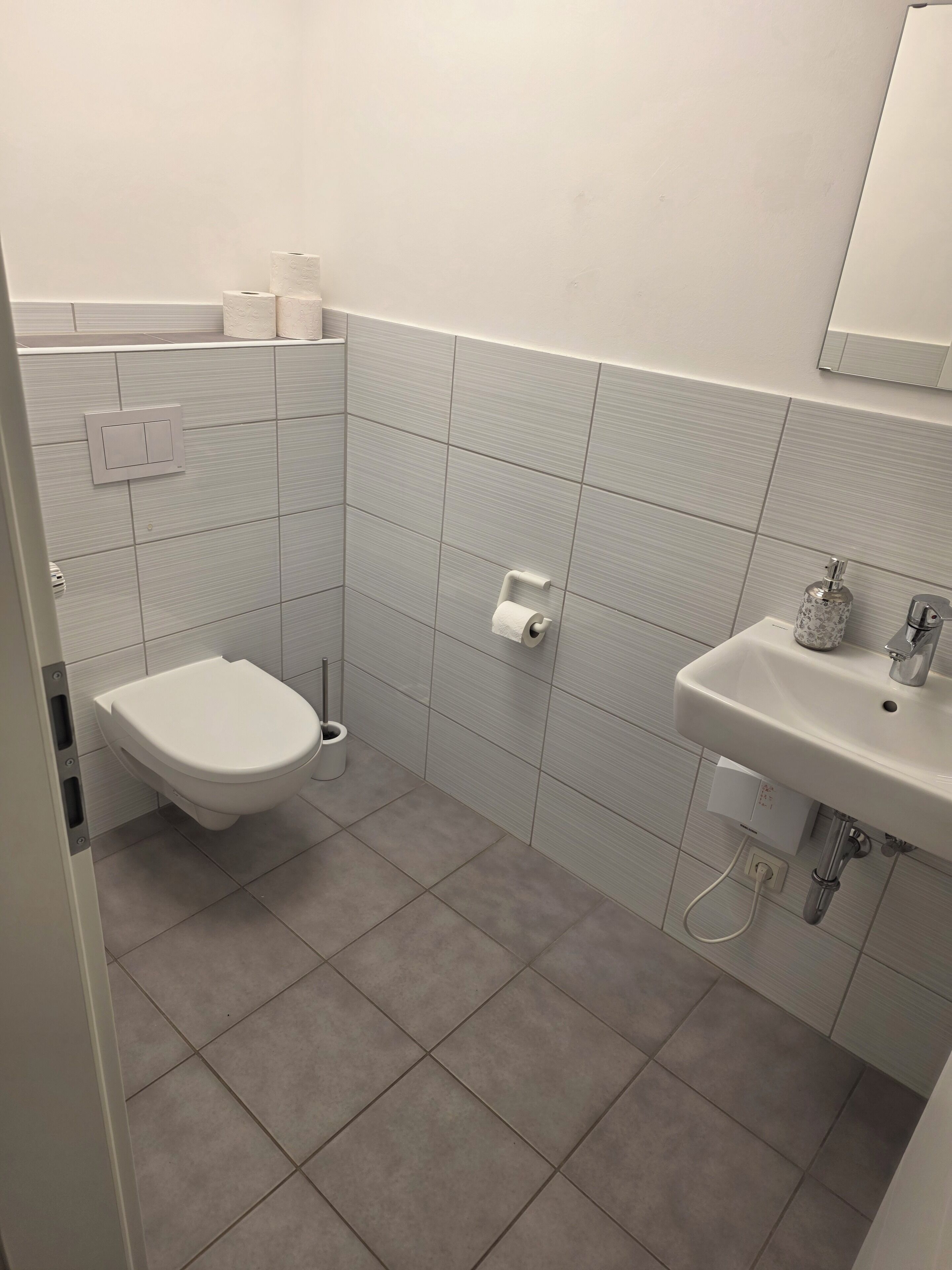 Un bagno con un water, un lavandino e uno specchio.