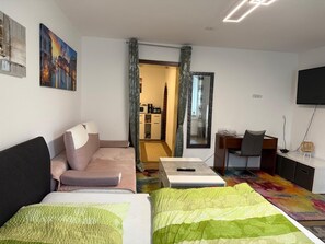 Une chambre d’hôtel moderne équipée d’un lit, d’un canapé, d’un bureau et d’une télévision.