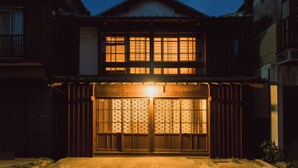A traditional Japanese building with a wooden facade, a tiled roof, and a large wooden gate.