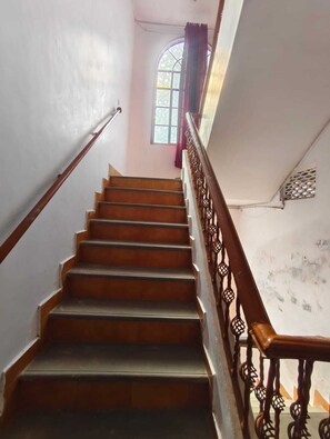 Una escalera con escalones de madera y barandilla de metal.