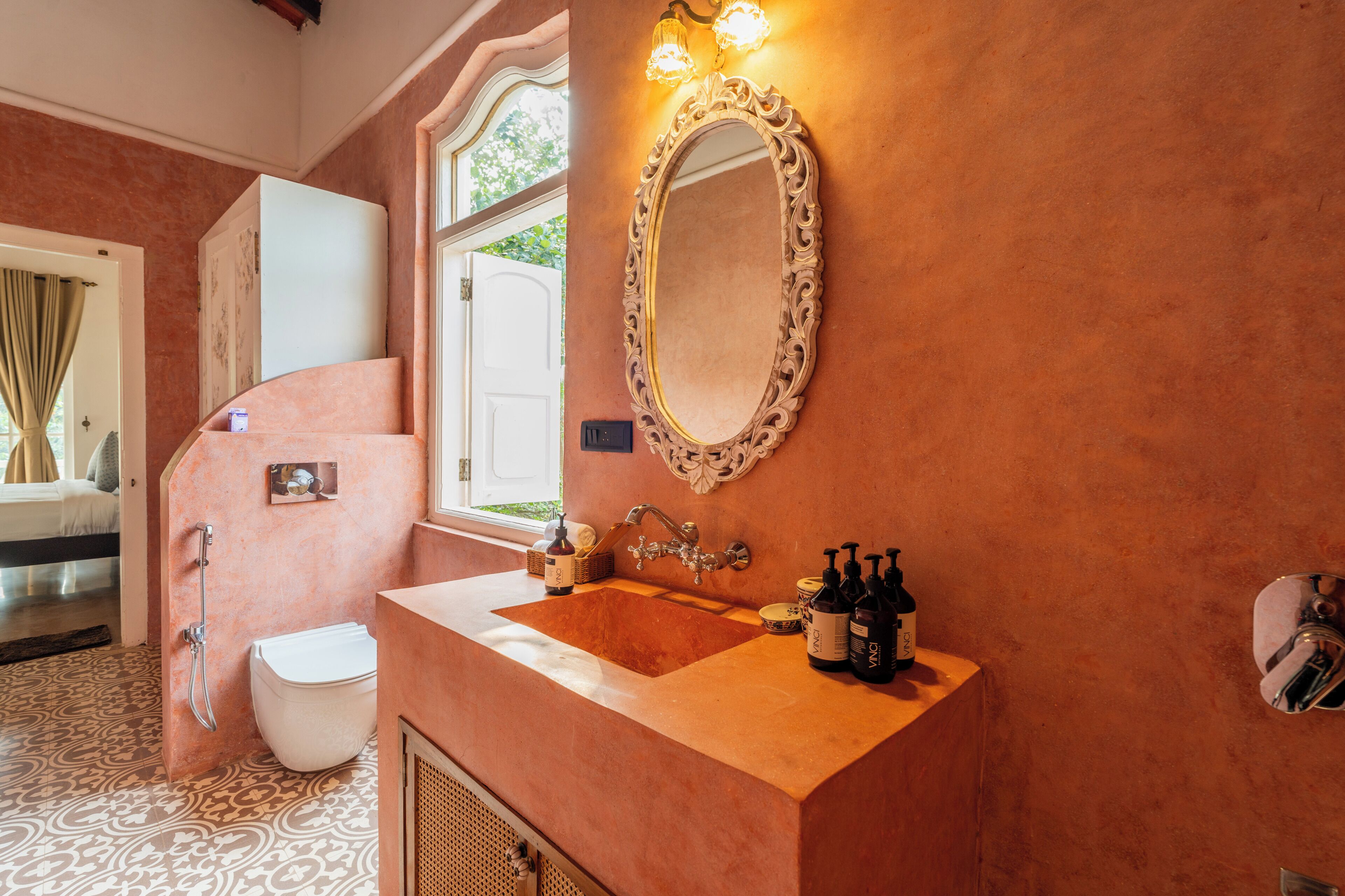 Un baño con lavamanos, espejo y artículos de aseo.