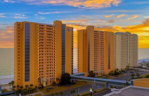 A multi-story hotel with balconies, a parking area, and a view of the ocean. - Splash Resort Luxury * Pools / Lazy River / Water Parks * Sept still Available (Panama City Beach)